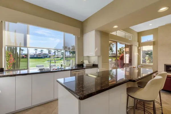 a dining hall with stainless steel appliances granite countertop a granite counter tops and a large window