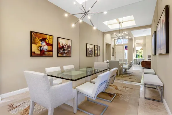 a living room with couches a dining table and couches with a flat screen tv
