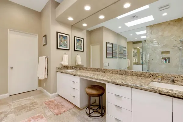 a bathroom with a granite countertop sink a mirror and a shower