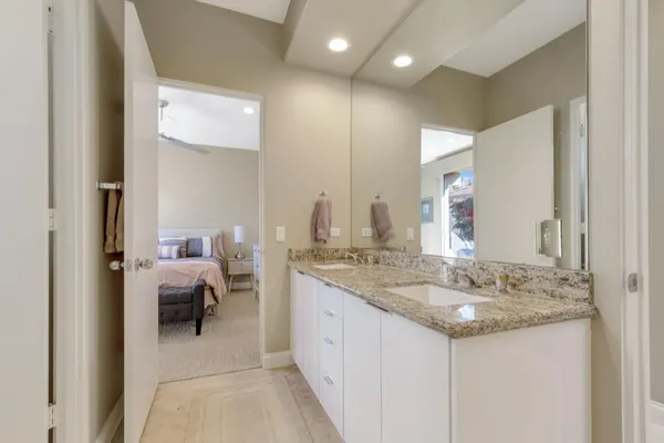 a spacious bathroom with a granite countertop sink and a mirror