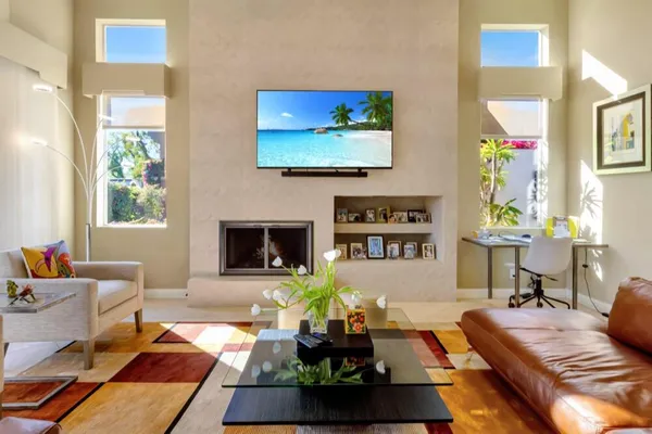 a living room with furniture a flat screen tv and a fireplace