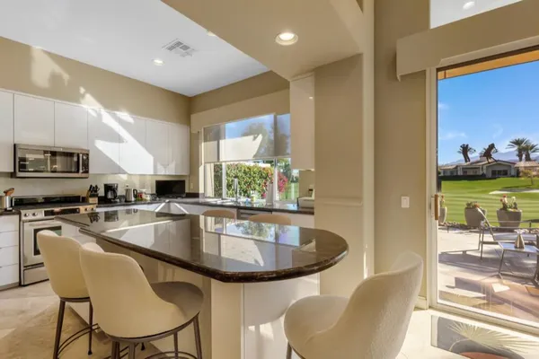 a kitchen with a table chairs sink and microwave