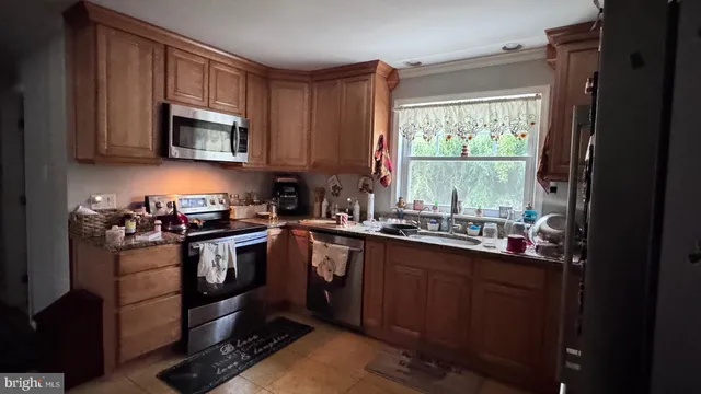a kitchen with stainless steel appliances granite countertop a sink stove and microwave