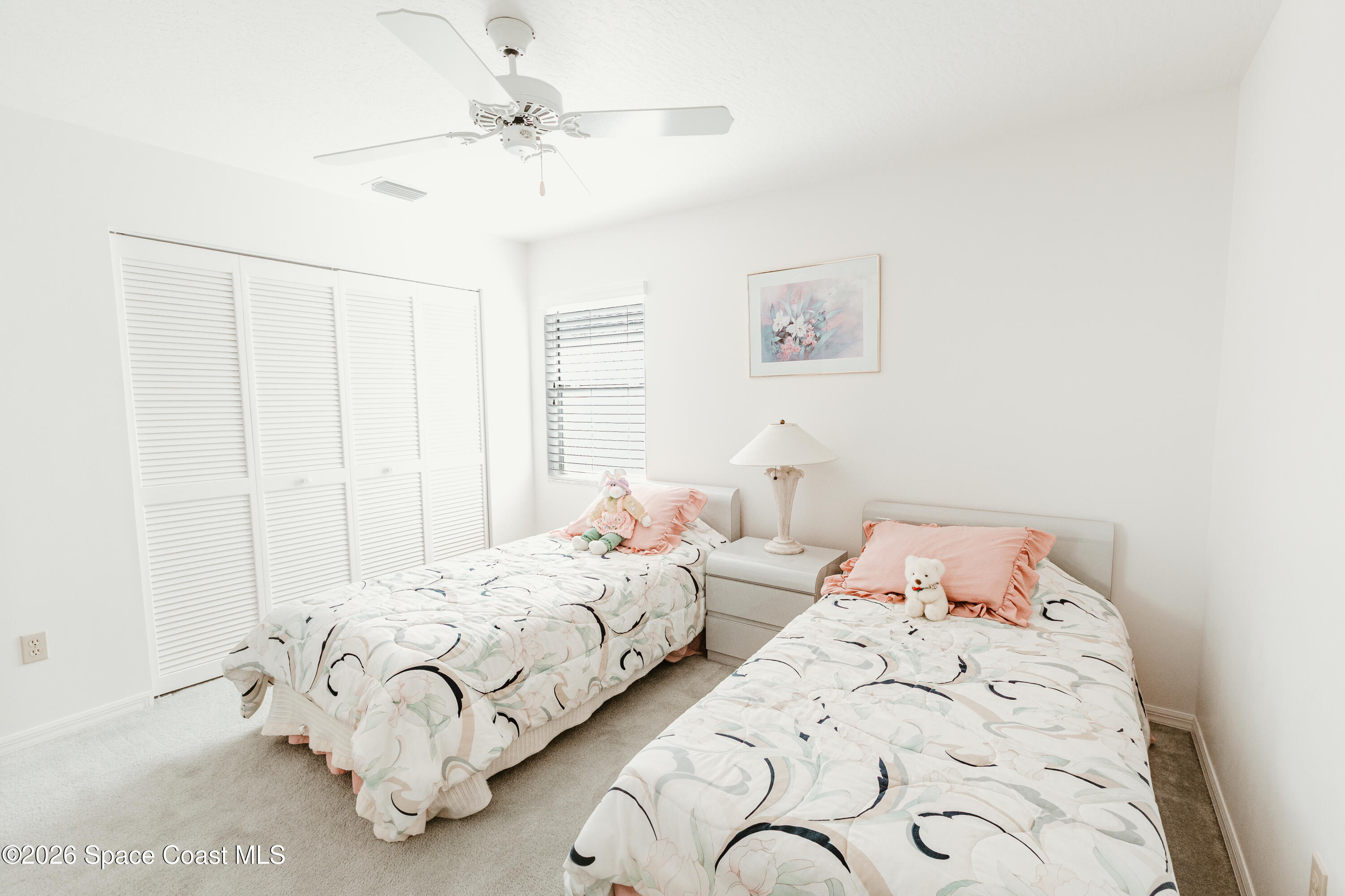905 Maplewood Court Melbourne, FL 32940 - Photo 11 of 23 a bedroom with two beds and a chandelier