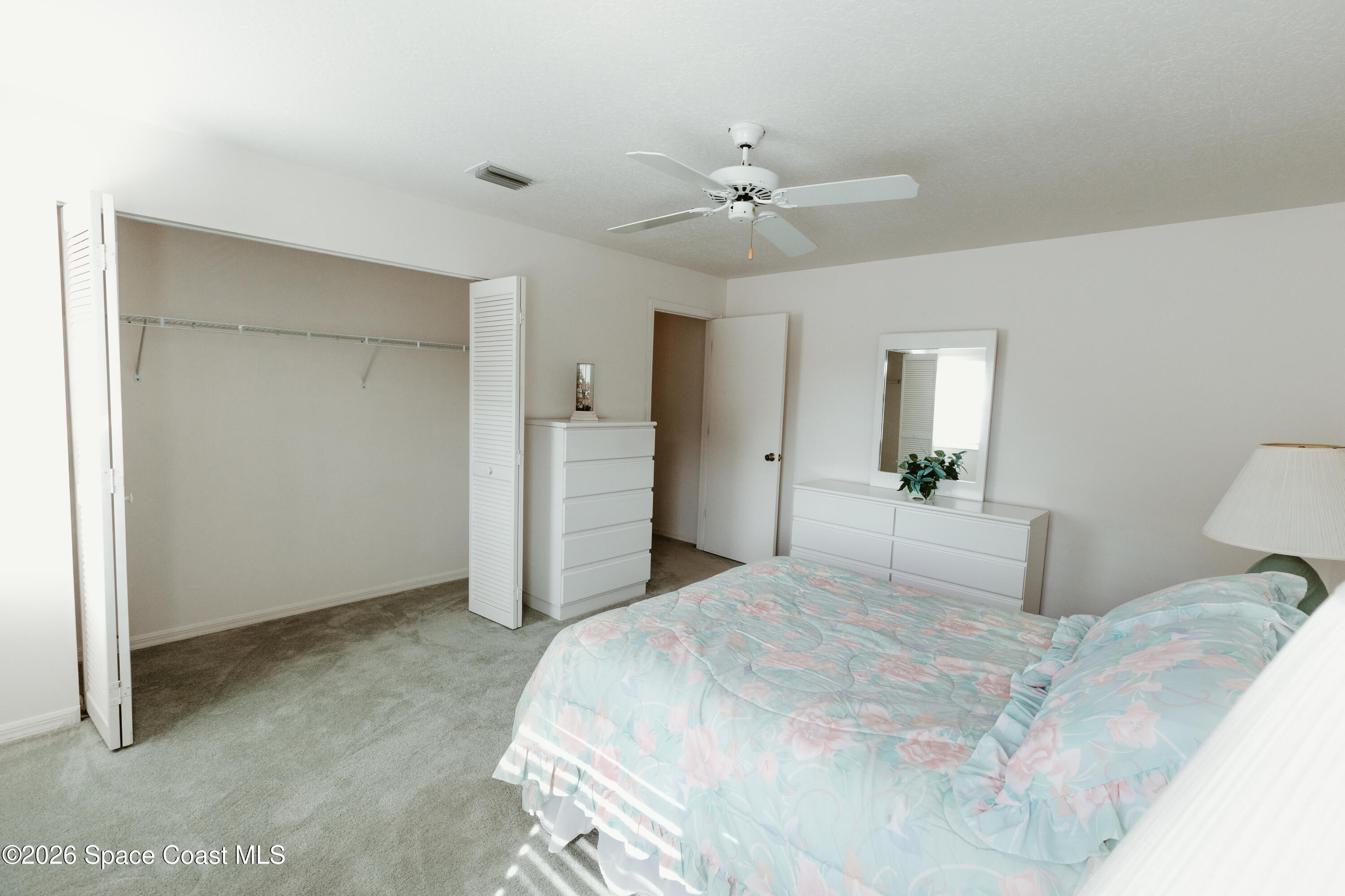 905 Maplewood Court Melbourne, FL 32940 - Photo 13 of 23 a bedroom with a large bed and a chandelier