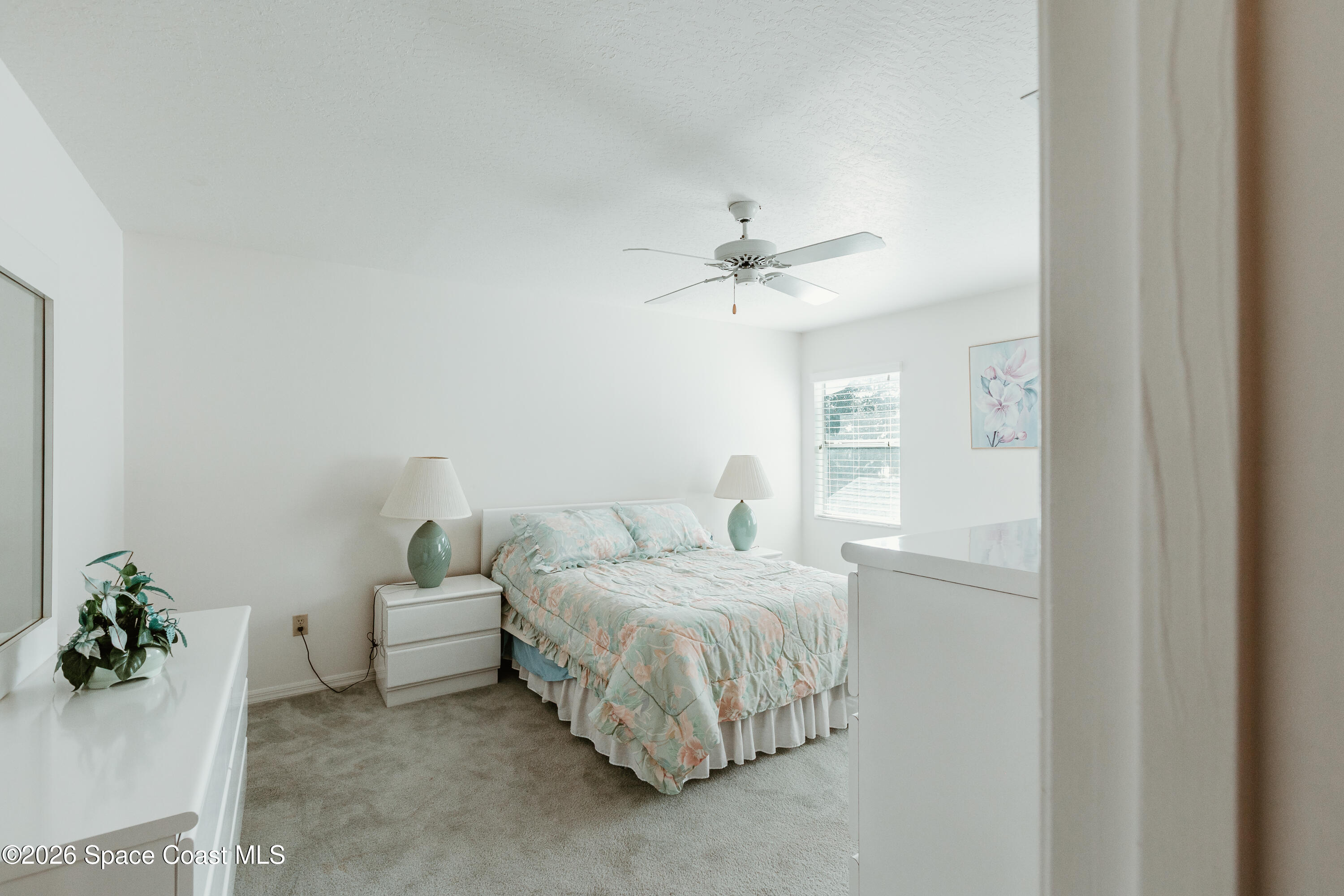 905 Maplewood Court Melbourne, FL 32940 - Photo 15 of 23 a bedroom with a bed and a chandelier