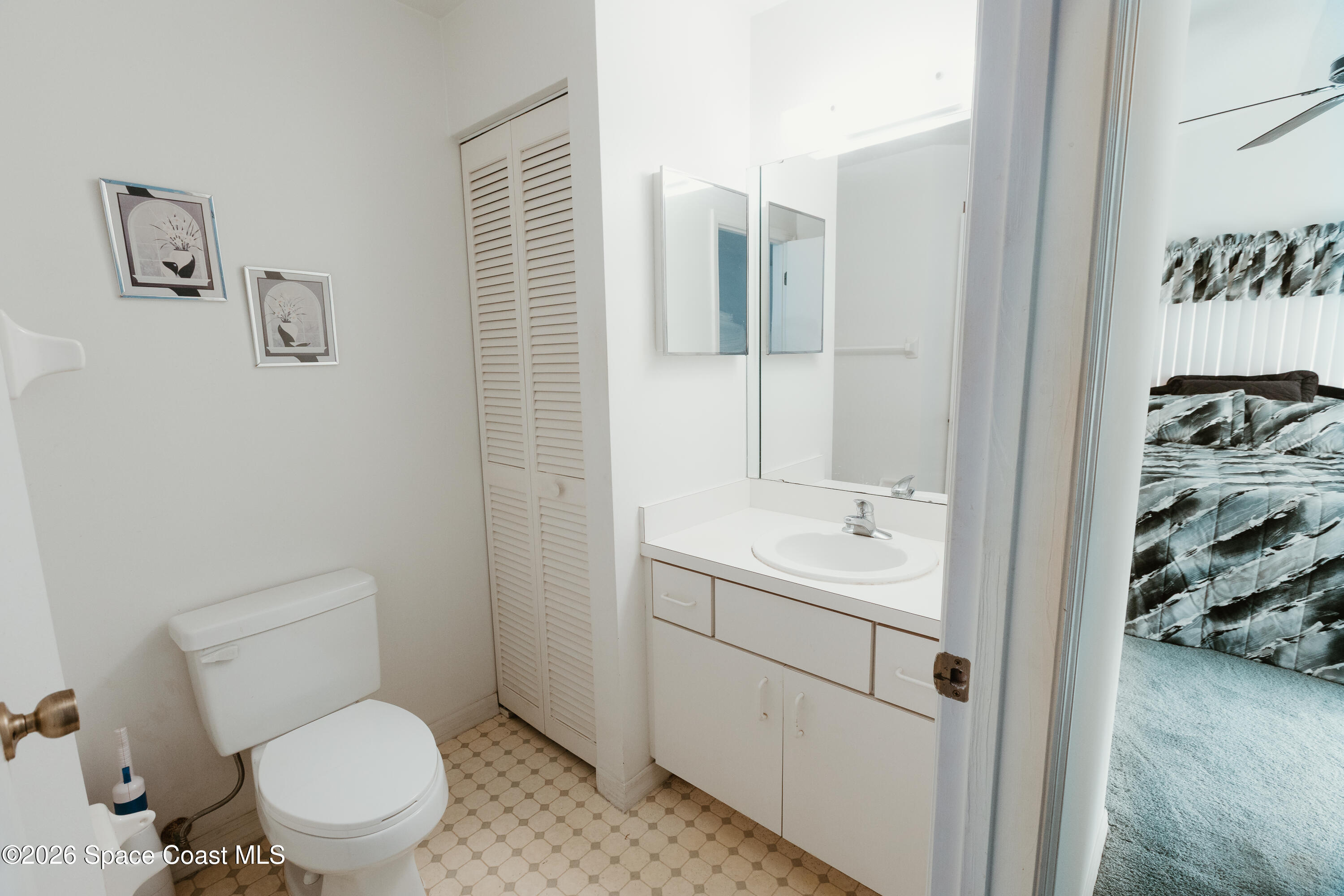 905 Maplewood Court Melbourne, FL 32940 - Photo 8 of 23 a bathroom with a toilet sink and mirror