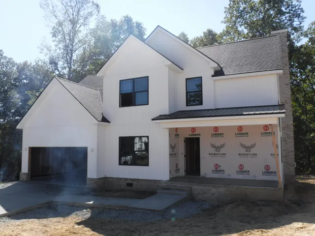 a view of a white house with a large tree