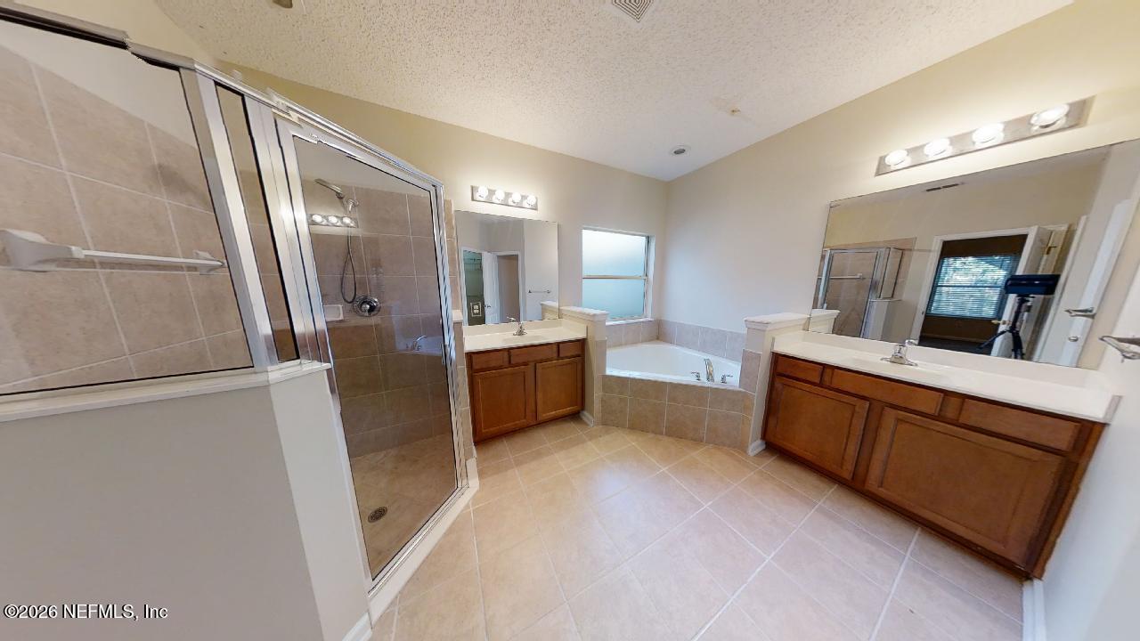 14454 Millhopper Road Jacksonville, FL 32258 - Photo 19 of 44 a large bathroom with a double vanity sink a mirror and a shower