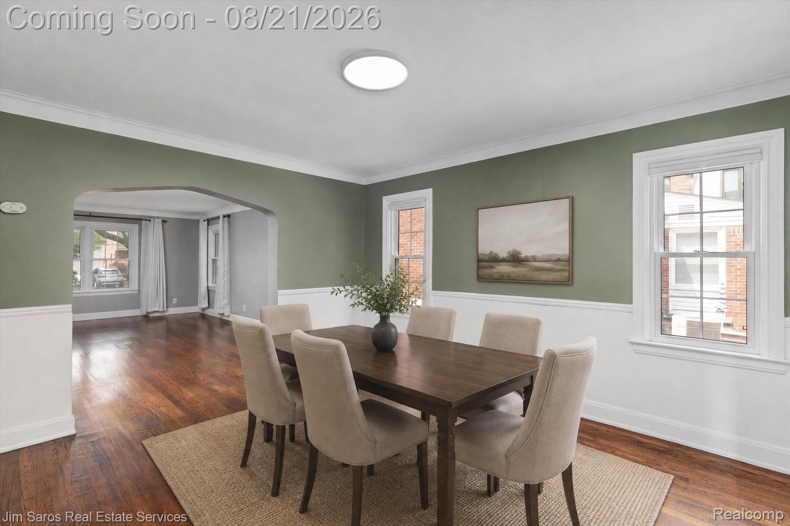 288 Moran Road Grosse Pointe, MI 48236 - Photo 5 of 24 Wood-finish flooring, white chair rail molding, decorative wall trim, an arched doorway, and a ceiling-mounted light fixture