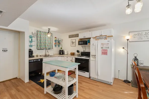 a kitchen with a refrigerator a stove a sink dishwasher and wooden floor