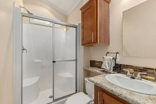 a bathroom with a granite countertop sink mirror and a toilet
