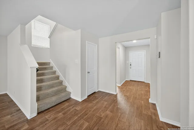 a view of a hallway with wooden floor and entryway