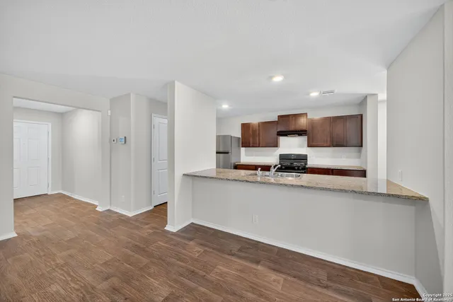 a view of kitchen with stainless steel appliances cabinets