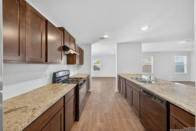 a kitchen with stainless steel appliances granite countertop a sink stove and refrigerator