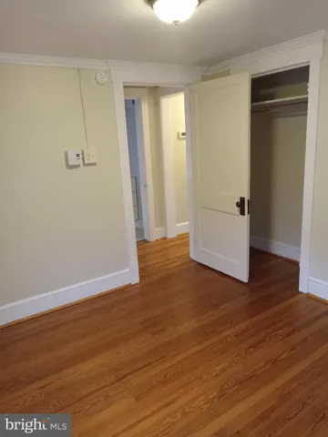 an empty room with wooden floor and closet