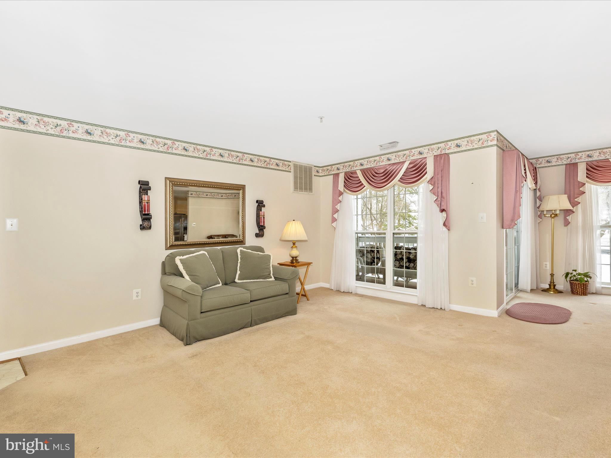 2501 Coach House Way, Unit 2C Frederick, MD 21702 - Photo 5 of 54 a living room with furniture a flat screen tv and a large window