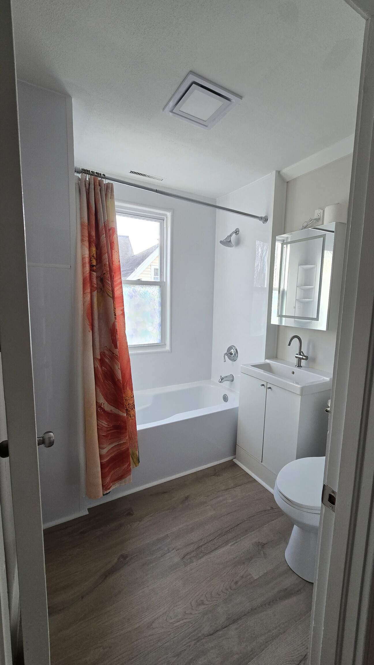 114 Wallace Street, Unit 3 New Britain, CT 06051 - Photo 3 of 11 a bathroom with a sink a toilet a window and a mirror