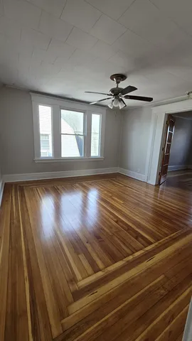 wooden floor in an empty room with a window