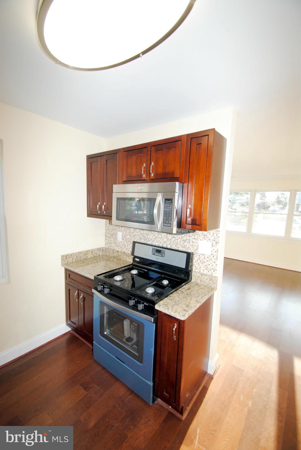 716 Milford Mill Road Baltimore, MD 21208 - Photo 11 of 19 a kitchen with stainless steel appliances granite countertop a stove a sink and a microwave