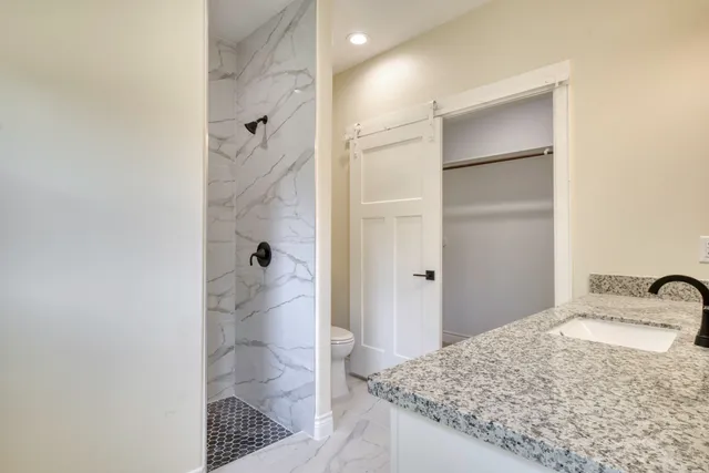 a bathroom with a granite countertop shower