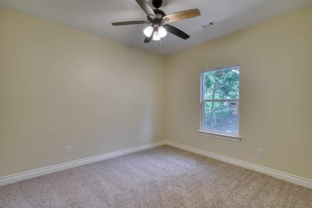 an empty room with a window and a fan
