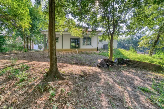 a view of a house with backyard and trees