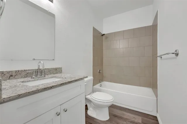 a bathroom with a granite countertop toilet a sink and bathtub