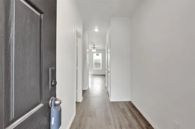 a view of a hallway with wooden floor