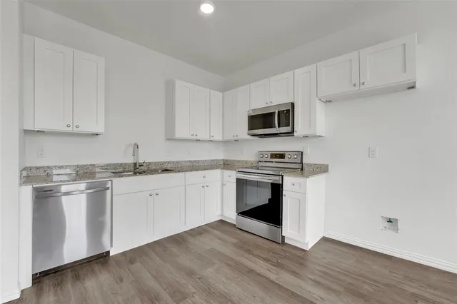 a kitchen with granite countertop a sink and steel appliances