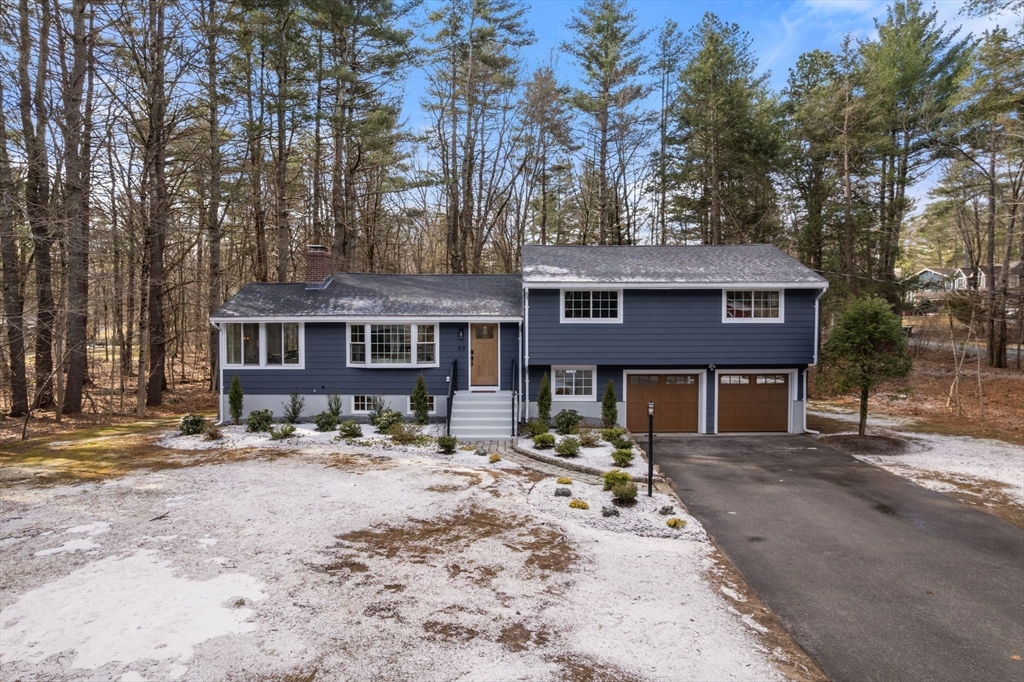 59 Tanbark Road Sudbury, MA 01776 - Photo 2 of 42 a front view of a house with a yard covered in snow