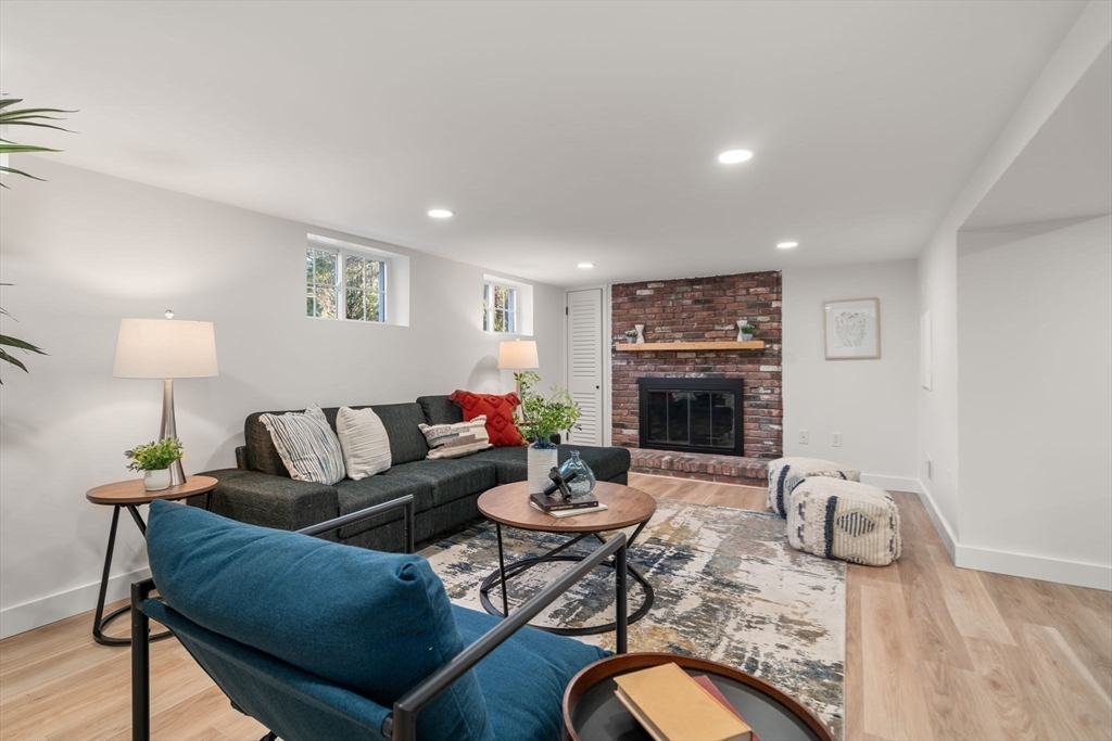 59 Tanbark Road Sudbury, MA 01776 - Photo 32 of 42 a living room with furniture a table and a fireplace