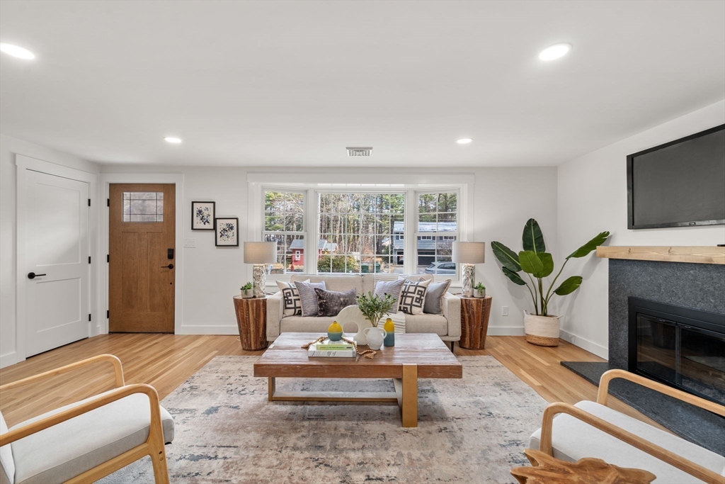 59 Tanbark Road Sudbury, MA 01776 - Photo 5 of 42 a living room with furniture a fireplace and a flat screen tv