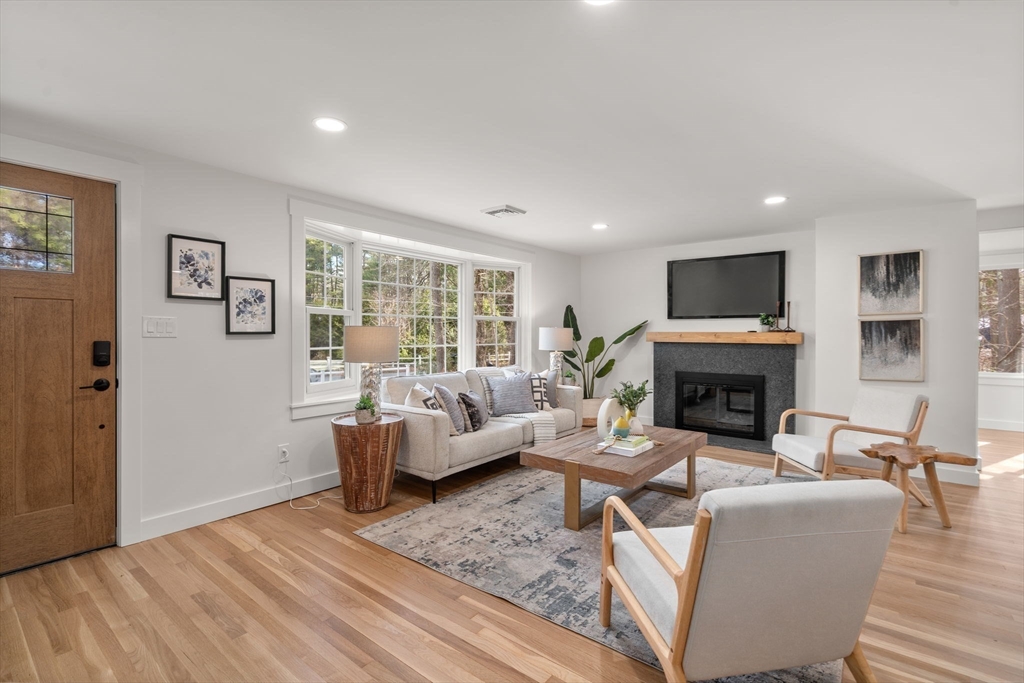 59 Tanbark Road Sudbury, MA 01776 - Photo 8 of 42 a living room with furniture large window and a fireplace