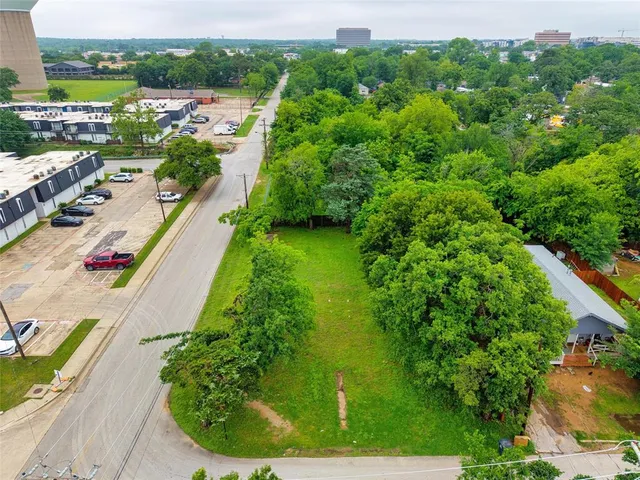 an aerial view of residential houses with outdoor space and trees