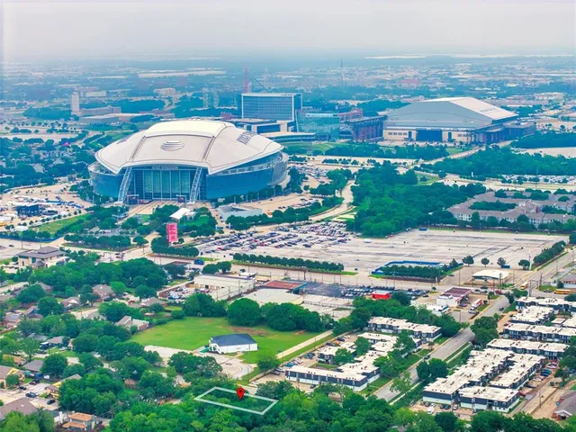 an aerial view of residential houses with outdoor space and parking