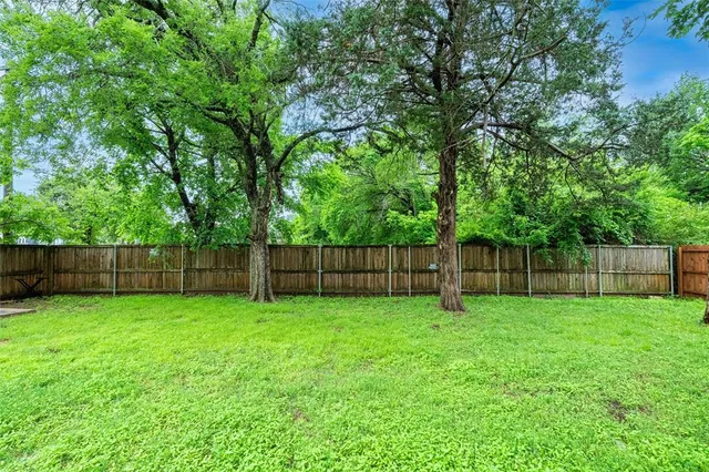 a view of a yard with wooden fence