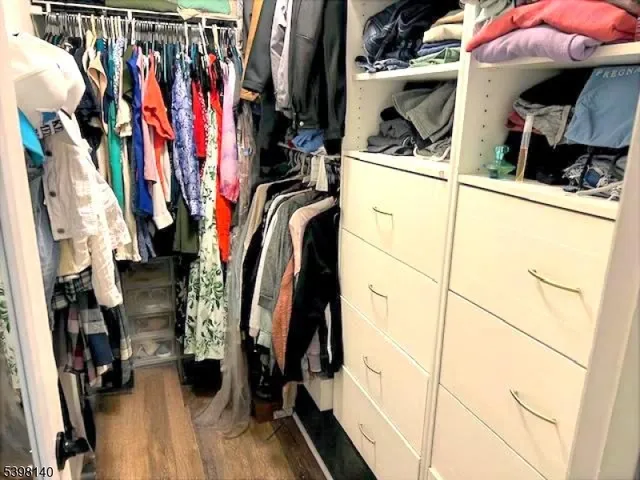 a view of walk in closet with clothes and shoes