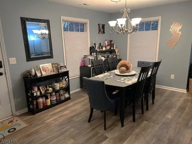 a dining room with furniture a chandelier and wooden floor