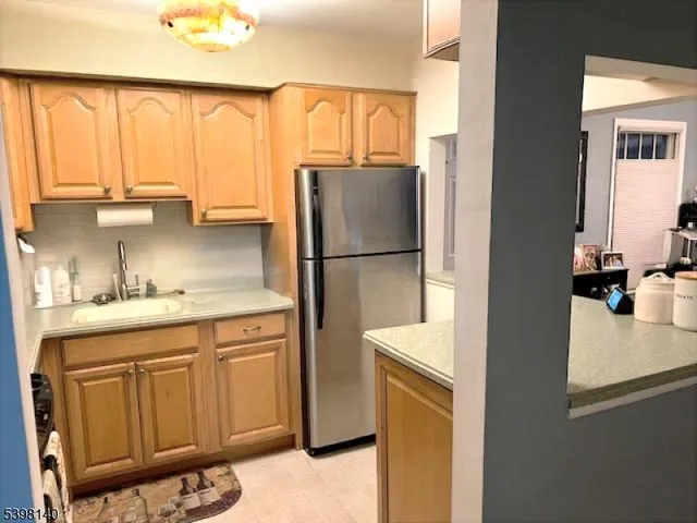 a kitchen with a refrigerator a sink and cabinets