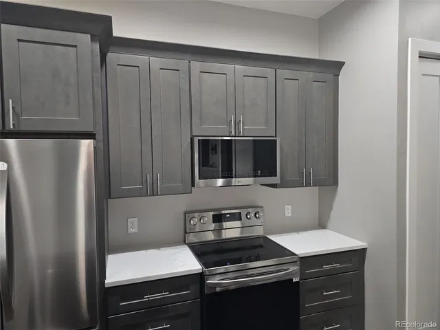 a kitchen with a refrigerator stove and cabinets