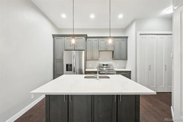 a kitchen with kitchen island a sink stainless steel appliances and cabinets