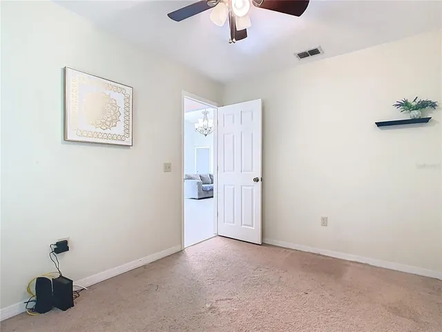 a large white bed in a bedroom next to a cabinet