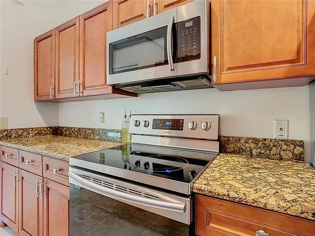 a kitchen with granite countertop a stove and a microwave