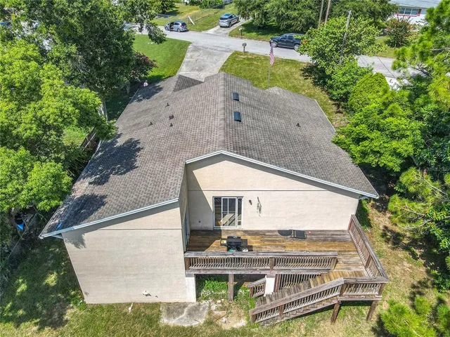 a backyard of a house with plants and large trees