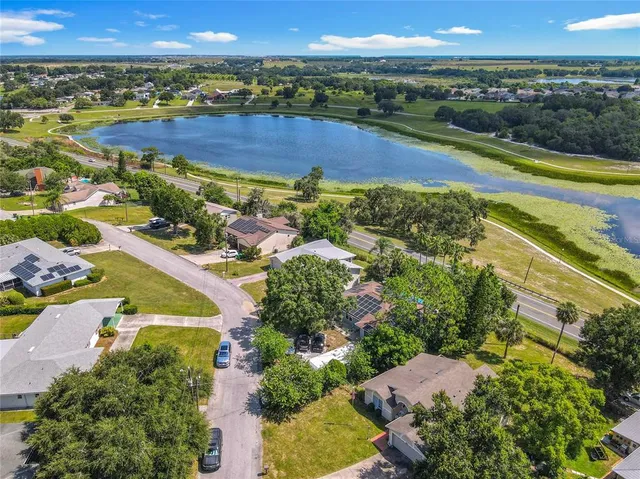 an aerial view of residential house with outdoor space and trees all around