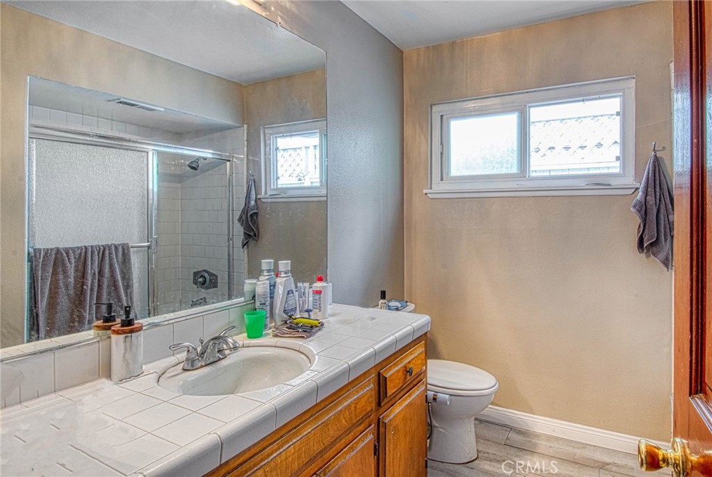 209 Walnut Street Newport Beach, CA 92663 - Photo 14 of 30 a bathroom with a granite countertop toilet a sink and a mirror