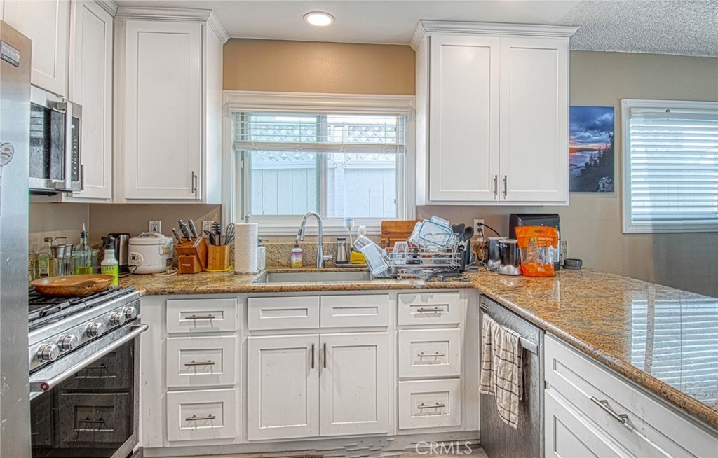 209 Walnut Street Newport Beach, CA 92663 - Photo 9 of 30 a kitchen with granite countertop a sink a stove and cabinets
