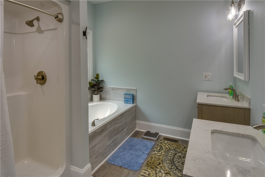 206 Petty Road Seneca, SC 29672 - Photo 29 of 48 Marble countertops and a large soaking tub create a luxurious bathroom retreat.