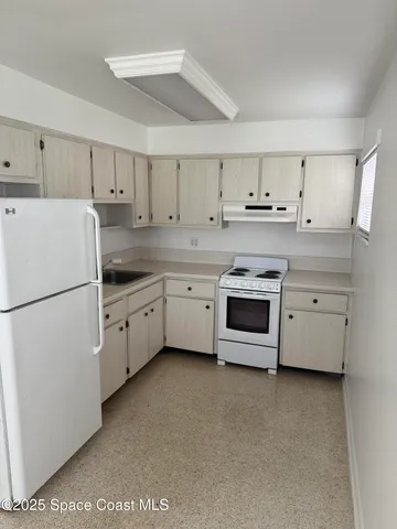 a kitchen with cabinets stainless steel appliances and sink